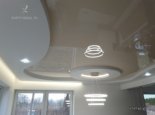 Wielopoziomowy sufit z LED i żyrandolem w salonie
