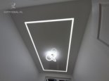 Biały sufit napinany z żyrandolem i liniami świetlnymi