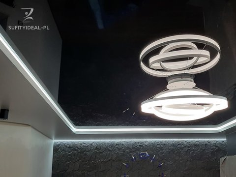 Sufit dwupoziomowy czarny biały z żyrandolem i LED w salonie